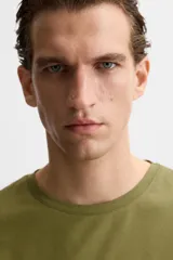 Camiseta slim fit de cuello redondo y manga corta, confeccionada en tejido de algodón con elasticidad.