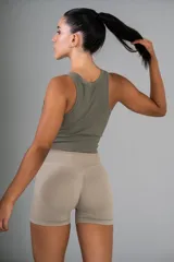 Top corto deportivo color verde oliva, de tejido acanalado, con cuello redondo y sisas anchas.