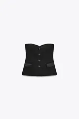 Top bustier negro con escote corazón y hombros descubiertos. Presenta detalle de solapas delanteras combinadas con tejido satinado a tono y cierre frontal con botones.
