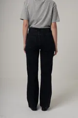 Jean de calce recto y tiro alto, color azul oscuro. Presenta costuras verticales en el frente.