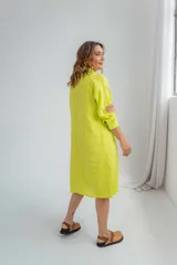 Vestido camisero color verde lima de lino, con cuello clásico, cierre frontal con botones y mangas largas con puños abotonados.