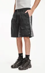 Bermuda deportiva color negro con paneles laterales grises. Presenta cintura elástica con cordón de ajuste estampado, bolsillos laterales y un bolsillo cargo con solapa en el muslo derecho.