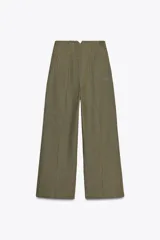 Pantalón color crema de lino, de tiro alto, corte recto y bolsillos delanteros.