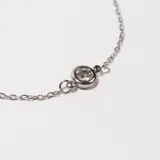 Pulsera plateada de acero con tres pequeños dijes circulares con incrustaciones de circonitas.