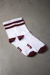 Medias deportivas blancas con rayas horizontales color bordó en la parte superior y logo en el tobillo.
