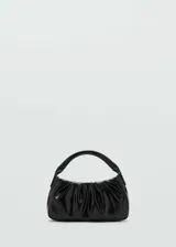 Bolso de mano negro con diseño acolchado, forro interior y doble asa corta.