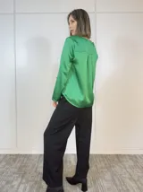 Blusa verde oliva de satén con cuello en V y mangas largas con puños abotonados.