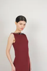 Vestido largo color borgoña, sin mangas, con escote bote decorado con lentejuelas.