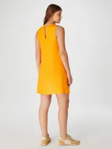 Vestido corto color salmón, de corte recto y sin mangas.