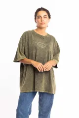 Remera verde militar con efecto gastado, corte oversize y estampado frontal con logo circular en color crudo.