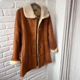 Tapado marrón de cuero con interior de piel sintética color crema, con cuello solapa y cierre con botones.