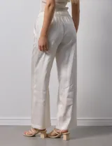 Pantalón palazzo color crudo, marca Nanette, con pretina elastizada, lazo de ajuste y bolsillos delanteros.