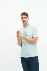 Remera verde agua de manga corta con estampado de dos peces y texto en azul marino.