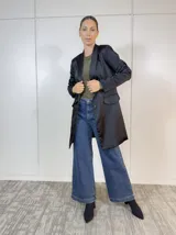 Blazer negro de corte clásico con solapas y bolsillos delanteros.