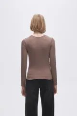 Remera gris de poliéster, de manga larga, corte ajustado y cuello redondo.
