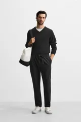 Pantalón de jogging color beige confeccionado en tejido de mezcla de algodón. Cuenta con cintura elástica ajustable con cordón, bolsillos frontales y traseros.