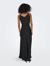 Top negro de punto acanalado con escote en V, sin mangas y tirantes con hebillas metálicas doradas.