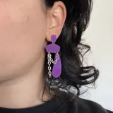 Aretes de acrílico en color violeta con detalles metálicos y cadenas.