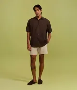 Bermuda de microfibra color beige, con cintura elástica y cordón ajustable. Presenta textura en el tejido y un bolsillo lateral.