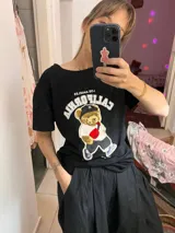 Remera negra de corte holgado con estampado de un oso con gorra y riñonera, y texto "California Los Angeles" en blanco.