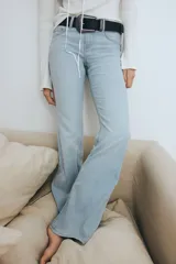 Pantalón de jean celeste de tiro bajo, corte ajustado en la cadera y acampanado desde la rodilla.