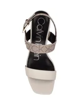 Sandalias de tacón Calvin Klein color beige con estampado del logo de la marca. Tiras de cuero sintético color crema y ajuste con hebilla.