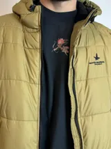 Campera inflada color ocre con capucha y cierre frontal.