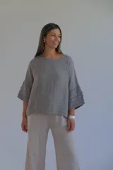Blusa gris confeccionada en lino italiano, de corte holgado, con escote redondo y mangas 3/4 con volados.