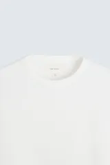Camiseta blanca de manga larga con cuello redondo y textura cuadriculada.