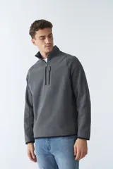 Buzo polar de algodón color bordó, con cuello elevado, medio cierre frontal, bolsillo con cierre en el pecho y logo estampado.