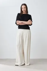 Blusa negra con textura amasada, de mangas cortas y corte holgado.