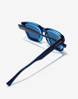 Lentes de sol unisex Hawkers, con montura cuadrada azul y lentes espejados azules.
