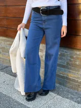 Pantalón de jean azul de corte recto y tiro alto, con cinturón de cuero negro con hebilla plateada.