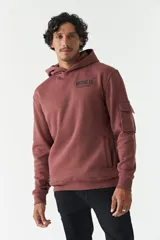 Canguro color ladrillo de felpa con capucha, bolsillo tipo canguro, bolsillo con botón en la manga y lettering estampado en la espalda.