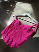 Corset fucsia de encaje con breteles finos regulables.