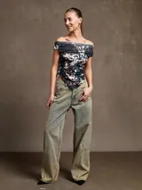 Top negro con escote off-shoulder y corte irregular en el ruedo.