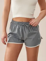 Short deportivo gris con cintura elástica ajustable con cordón y ribete blanco en ruedo y laterales.