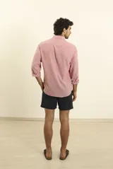 Camisa azul marino de lino y algodón, con cuello abotonado, manga larga con puños enrollados, bolsillo de parche en el pecho y cierre frontal con botones.