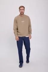 Buzo color arena de manga larga y cuello redondo, con logo "Originals Studio" estampado en el pecho.