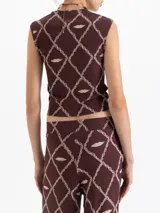 Musculosa de punto color marrón con estampado de cadenas y labios en forma de rombos. Presenta escote cuadrado y corte ajustado al cuerpo.