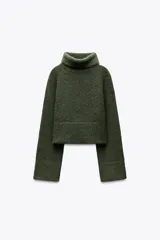 Sweater azul de tejido de punto grueso, con cuello alto y mangas largas acampanadas.