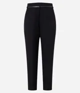 Pantalón de vestir azul marino, de corte zanahoria, con cinturón fino negro con hebilla dorada.