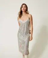 Vestido midi plateado de tirantes finos, cubierto completamente de lentejuelas. Presenta un escote en V ribeteado con encaje blanco y un sutil estampado floral en tonos pastel en la parte inferior.