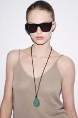 Collar con cordón de cuero negro y colgante de piedra facetada color verde oscuro.