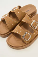 Sandalias bajas color beige con doble tira con hebilla y apliques de tachas.