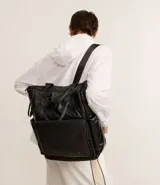 Mochila deportiva grande color negro, confeccionada en material sintético. Posee correa de mano y asas para la espalda, bolsillos funcionales y cierre por cremallera.