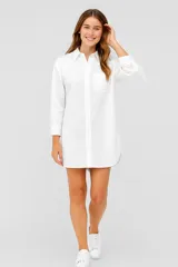 Camisa blanca de algodón con corte camisero, cuello clásico, manga larga con puños abotonados y bolsillo en el pecho.