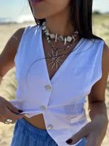 Collar corto con cuentas irregulares de nácar en tonos blanco, beige y marrón claro. Se cierra con cadena de acero quirúrgico y ganchito para regular el largo.
