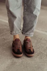 Zapatillas bajas de cuero color marrón con suela de goma color caramelo y cordones marrones.