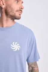 Camiseta de manga corta celeste con corte oversize y estampa en la espalda con un diseño de cuatro recuadros con motivos playeros y la frase "Pura Vida".